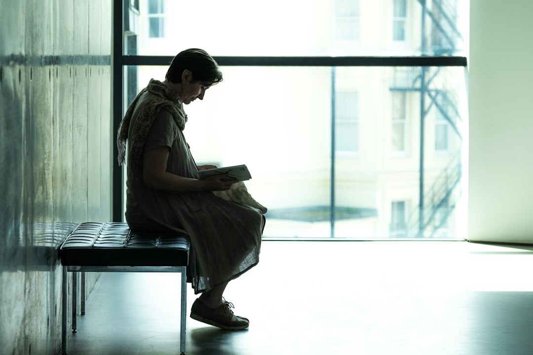 woman reading mystery novel by window